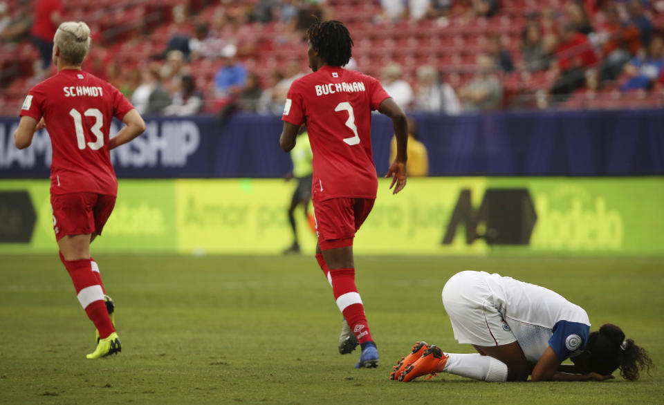 Panama midfielder Kenia Rangel, right, falls after attempting to advance the ball as Canada midfielder Sophie Schmidt (13) and defender Kadeisha Buchanan (3) run nearby during the first half of a soccer match at the CONCACAF women's World Cup qualifying tournament in Frisco, Texas, Sunday, Oct. 14, 2018. (AP Photo/Andy Jacobsohn)