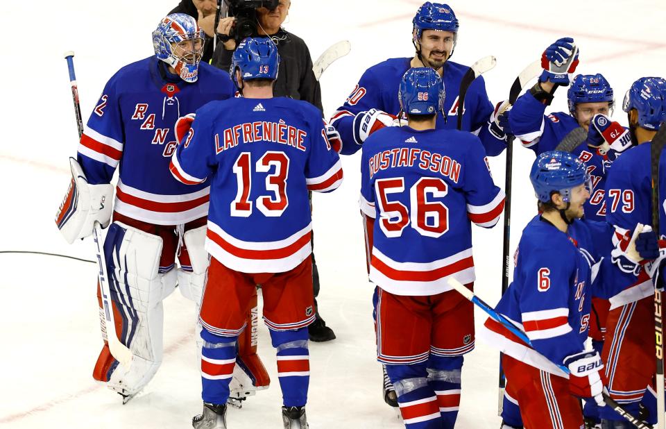 New York Rangers goaltender Jonathan Quick (32) and left wing Alexis Lafreniere (13) celebrate after defeating the Columbus Blue Jackets in a shootout of an NHL hockey game Sunday, Nov. 12, 2023, in New York. (AP Photo/Noah K. Murray)