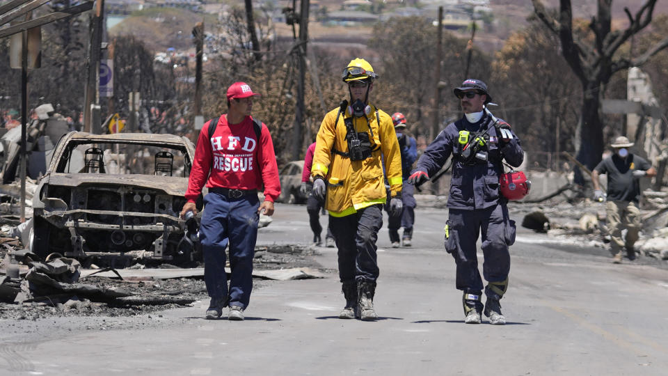 FILE - Members of a search-and-rescue team walk along a street, Saturday, Aug. 12, 2023, in Lahaina, Hawaii, following heavy damage caused by wildfire. (AP Photo/Rick Bowmer, File)