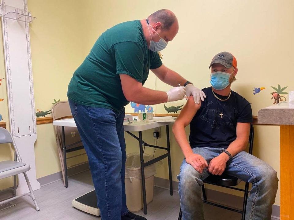 Ethan Weis, 20, of Chillicothe receives the second dose of his COVID-19 vaccine from a health care worker at the Livingston County Health Center on Thursday, June 17, 2021. Many in his rural community are hesitant to get vaccinated, but Weis wanted to do so to visit family members in nursing homes and avoid being required to wear a mask in restaurants.