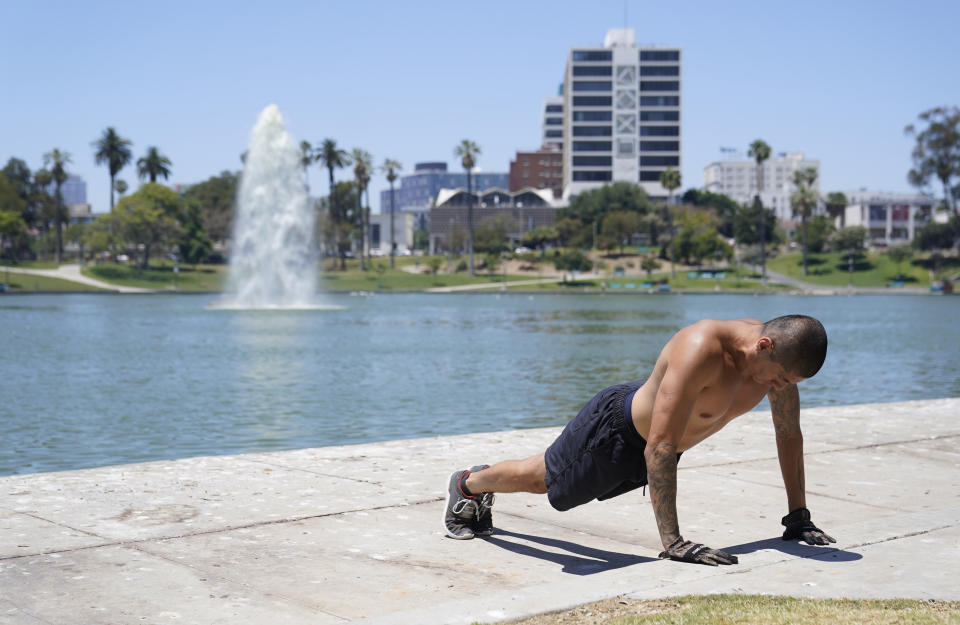 A man exercises shirtless as temperatures rise at MacArthur Park Tuesday, July 11, 2023, in Los Angeles. (AP Photo/Marcio Jose Sanchez)