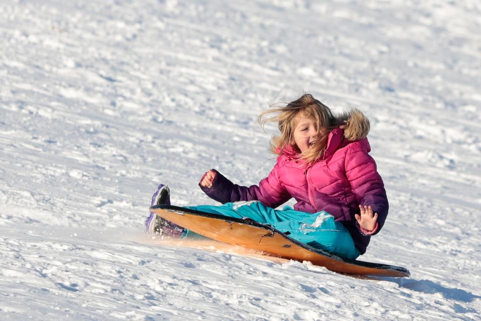 A young girl is all smiles as she makes her way down the hill at Potato Hill in Westport.