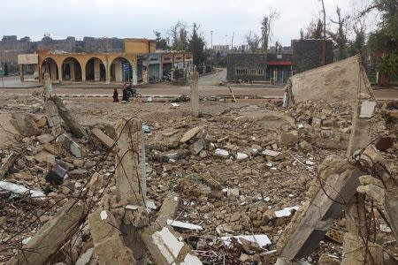 Civilains walk past the rubble of damaged buildings in the rebel held historic southern town of Bosra al-Sham, Deraa, Syria February 23, 2016. REUTERS/Alaa Al-Faqir