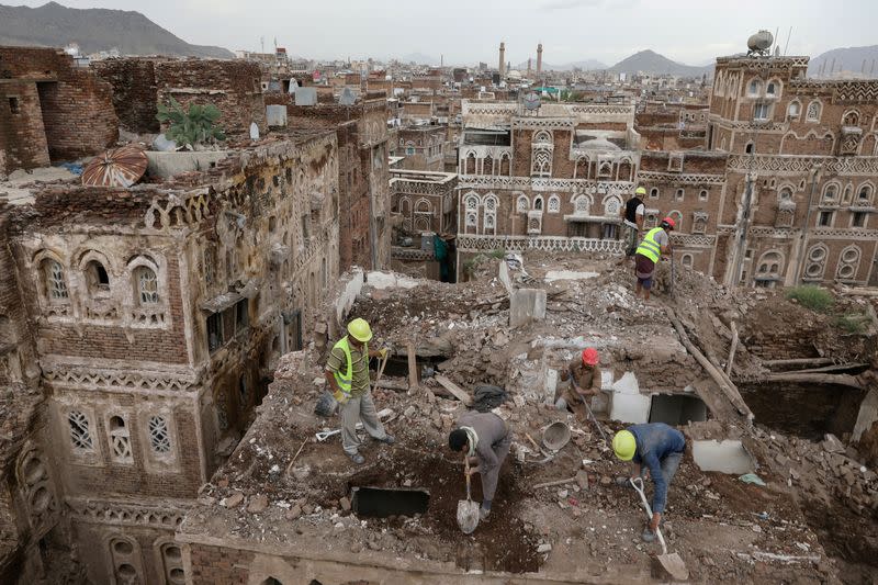 Workers demolish a building damaged by rain in the UNESCO World Heritage site of the old city of Sanaa