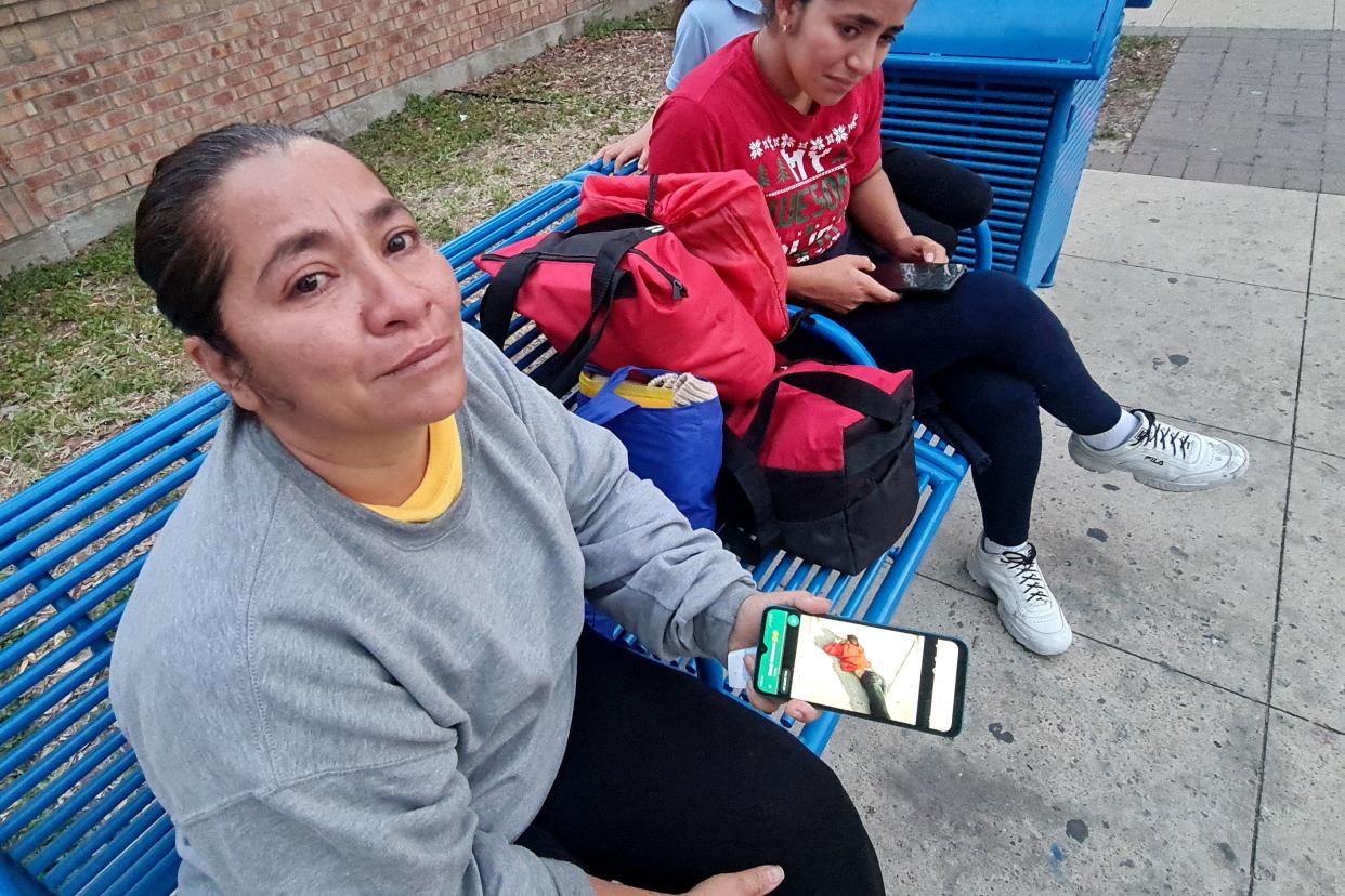 Venezuelan Maria Cabarcas (L), 43, holds her phone with the picture of who she believes is her deceased son, Enyerbeth Cabarcas, 23, who allegedly was one of the eight victims after an SUV plowed into a crowd, in Brownsville, Texas on 8 May 2023 (AFP via Getty Images)