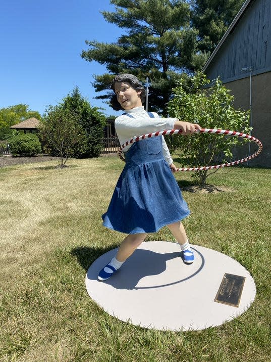 "Attic Trophy," by Seward Johnson shows a child trying a  Hula Hoop, a toy first popularized in the late 1950s.