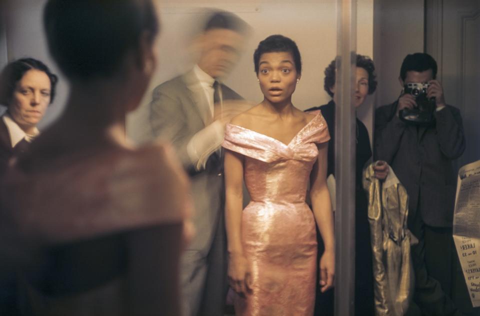 American actress and singer Eartha Kitt (1927 - 2008) looks at her reflection in a full-length mirror as French fashion designer Hubert de Givenchy (1927 - 2018) adjusts her dress during a fitting, Paris, France, 1961. (Photo by Tony Vaccaro/Getty Images)