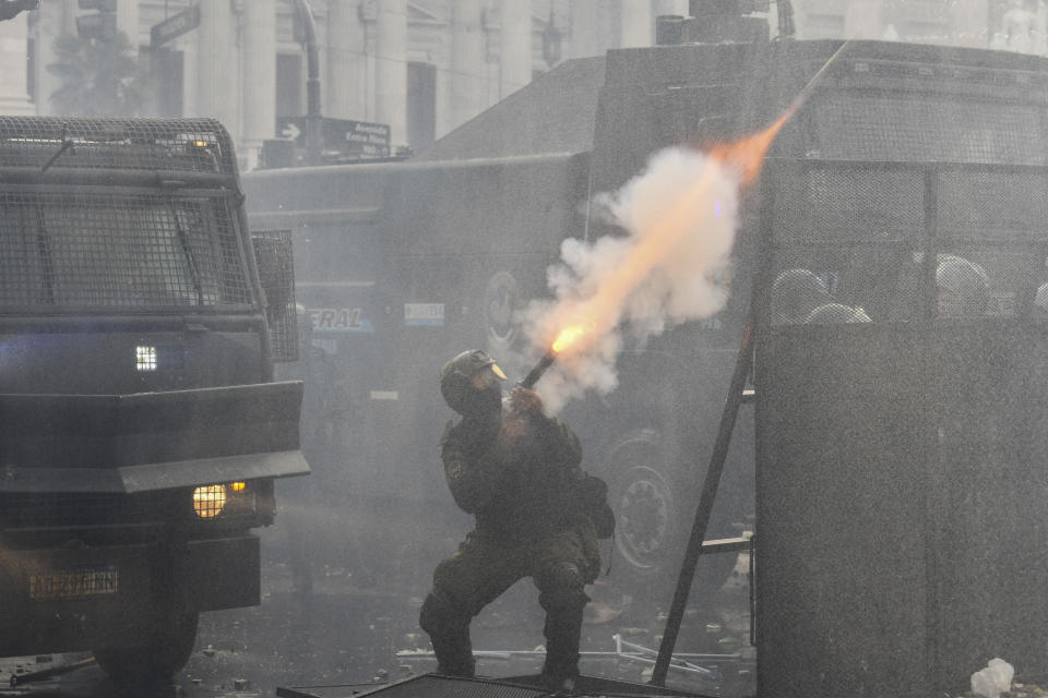 Un policía lanza gas lacrimógeno en enfrentamientos con manifestantes contra el gobierno en las afueras del Congreso, donde senadores debaten reformas impulsadas por el presidente argentino, Javier Milei, en Buenos Aires, Argentina, el miércoles 12 de junio de 2024. (AP Foto/Gustavo Garello)