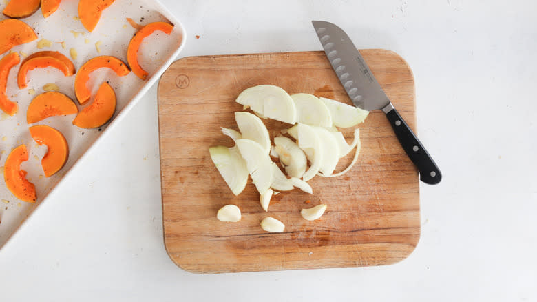 sliced onions on cutting board with knife
