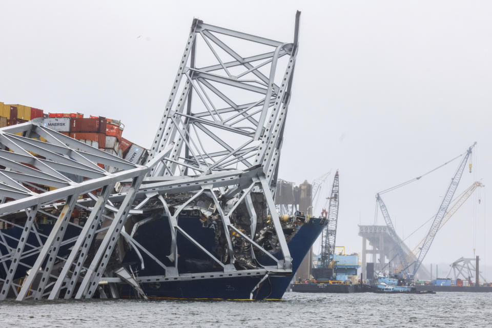 Cranes continue salvage work as wreckage of the Francis Scott Key Bridge rests on the container ship Dali, Wednesday, April 3, 2024, in Baltimore. (AP Photo/Julia Nikhinson)