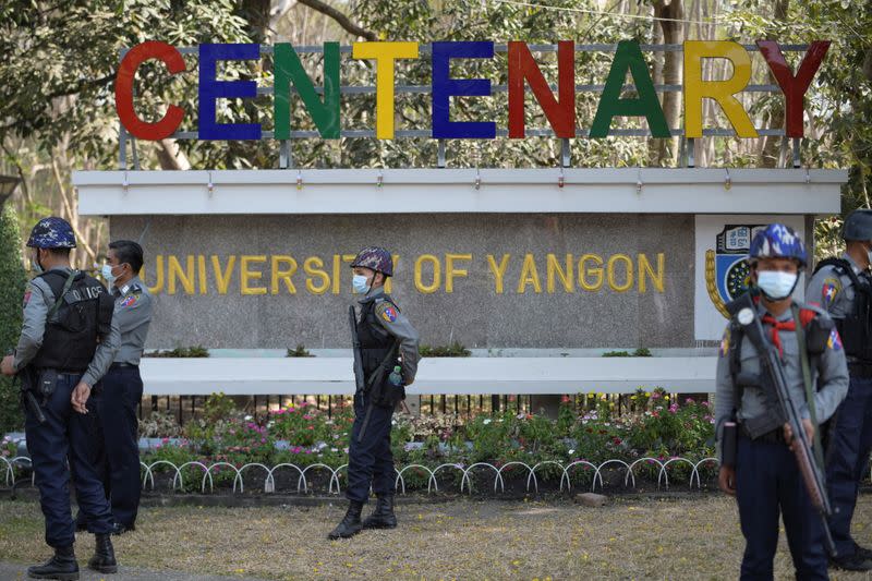 Riot police officers stand guard during a rally against the military coup at the University of Yangon