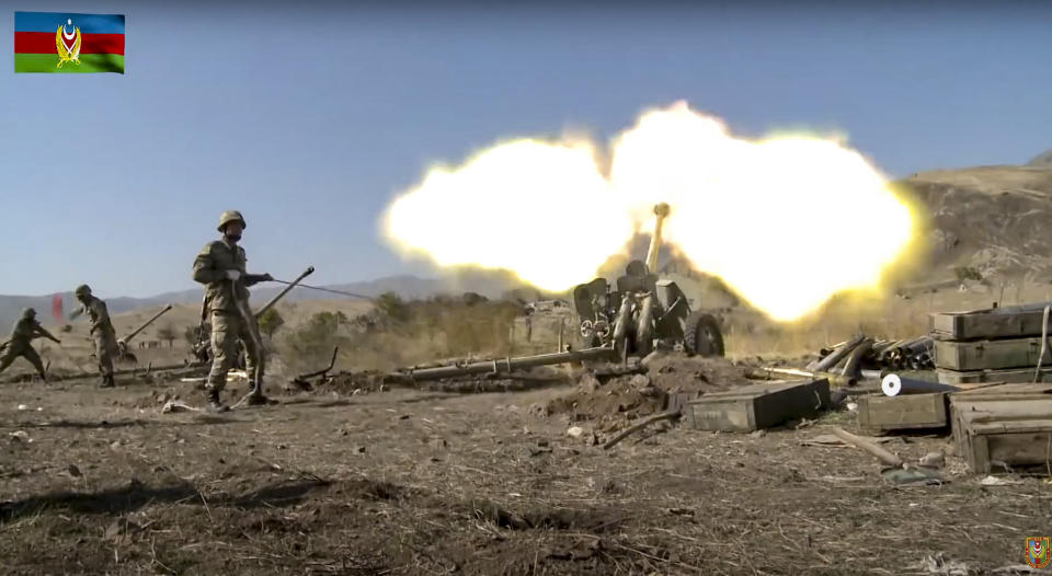 In this image taken from video released by Azerbaijan's Defense Ministry on Tuesday, Oct. 20, 2020, Azerbaijan army soldiers fire an artillery piece during fighting with forces of the self-proclaimed Republic of Nagorno-Karabakh. Azerbaijan Defense Ministry claims that Armenian forces tried to carry out an offensive that was met by an artillery strike from Azerbaijan, causing a large number of casualties among Armenian forces. (Azerbaijan's Defense Ministry via AP)