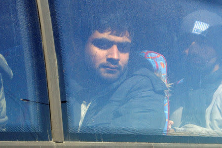 Undocumented migrants are seen on a police bus after being arrested during an operation to dismantle an international smuggling ring at the city of Heraklion on the island of Crete, Greece, March 3, 2017. REUTERS/Stefanos Rapanis