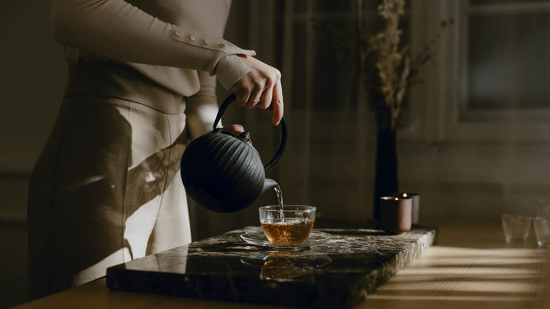 Woman pouring tea into cup