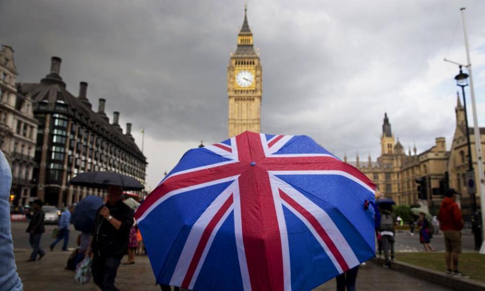 Person with umbrella outside the houses of parliament