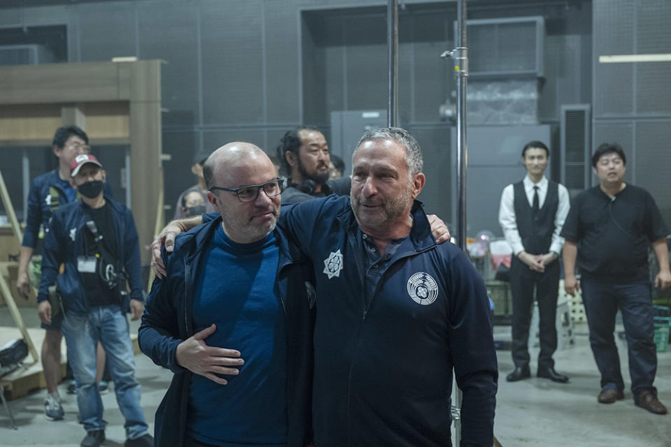 J.T. Rogers (left with eyeglasses) and Alan Poul (on the right) hugging each other on set of Tokyo Vice