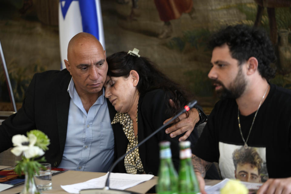 Relatives of hostages taken by Hamas on Oct. 7, Alon Nimrodi, left, hugs Meirav Gilboa-Dalal, as her son Gal Gilboa-Dalal talks during a press conference in Rome, Monday, April 8, 2024. Pope Francis met Monday with relatives of hostages taken by Hamas on Oct. 7, marking the six-month anniversary of the attack in southern Israel with an hourlong audience. (AP Photo/Alessandra Tarantino)