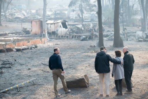 US President Donald Trump (C) hugged Paradise Mayor Jody Jones (2R) while surveying the remains of the California town of Paradise