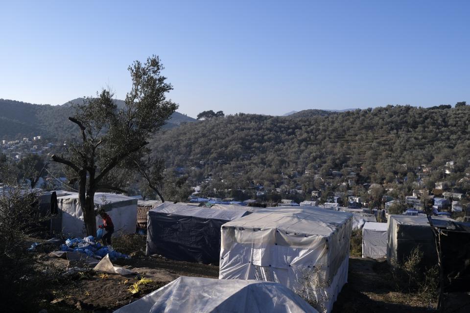 A migrant man holds a plastic bag outside the Moria refugee camp on the northeastern Aegean island of Lesbos, Greece, on Wednesday, Jan. 22, 2020. Some businesses and public services on the eastern Aegean island are holding a 24-hour strike on Wednesday to protest the migration situation, with thousands of migrants and refugees are stranded in overcrowded camps in increasingly precarious conditions. (AP Photo/Aggelos Barai)