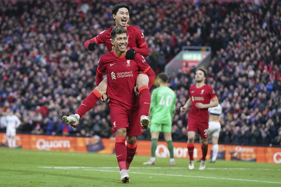 Liverpool's Takumi Minamino, top, celebrates with Liverpool's Roberto Firmino after scoring his side's third goal during an English Premier League soccer match between Liverpool and Brentford at Anfield in Liverpool, England, Sunday, Jan. 16, 2022. (AP Photo/Jon Super)