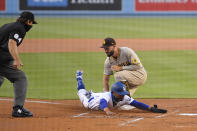 Los Angeles Dodgers' Mookie Betts, right, is tagged out by San Diego Padres' Eric Hosmer after getting caught in a rundown as home plate umpire John Libka watches during the first inning of a baseball game Monday, Aug. 10, 2020, in Los Angeles. (AP Photo/Mark J. Terrill)