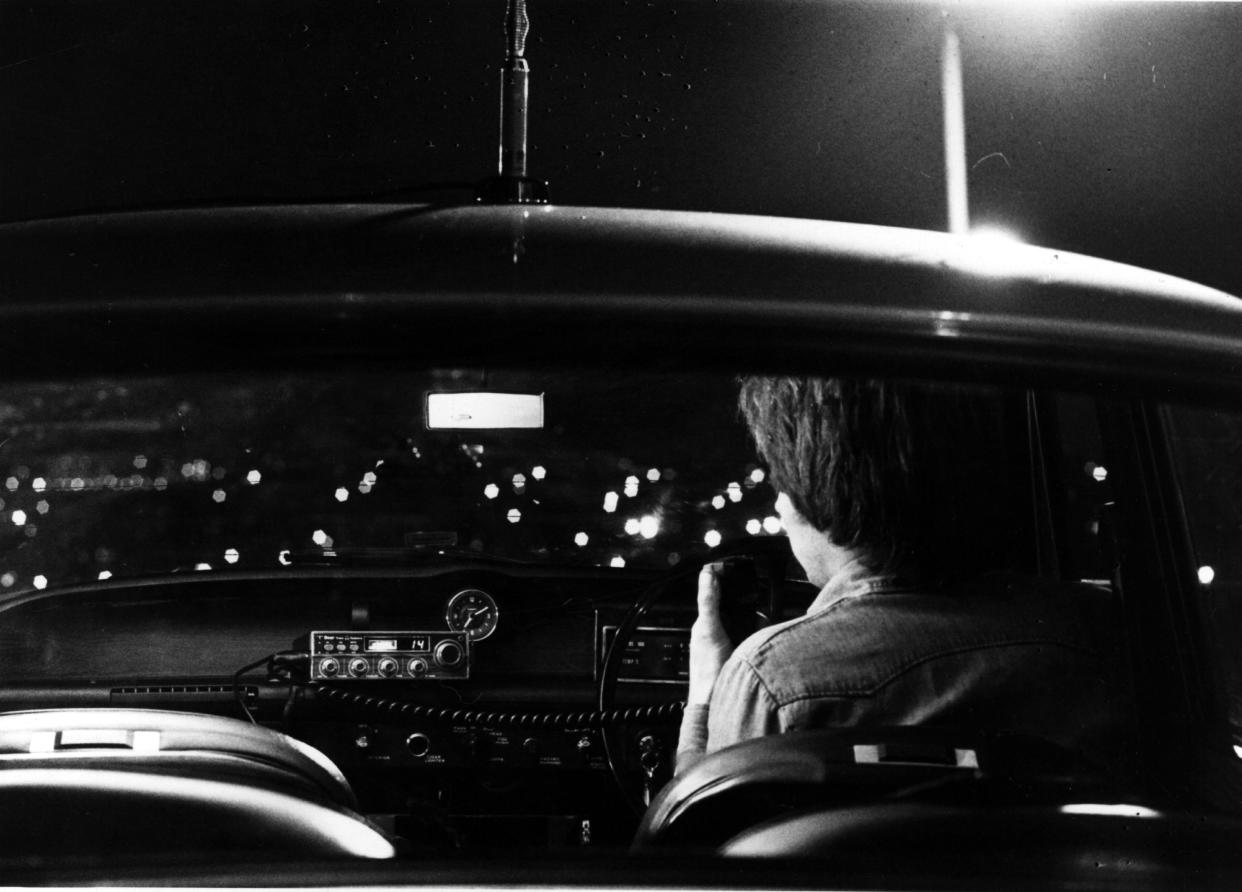 1978: A car driver communicating using Citizens Band radio.