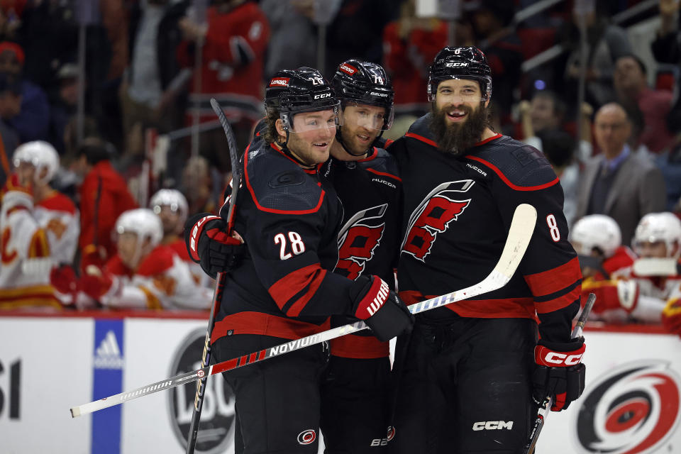 Carolina Hurricanes' Brent Burns (8) celebrates his goal with Carolina Hurricanes' Jaccob Slavin, center, and Brendan Lemieux (28) during the second period of an NHL hockey game against the Calgary Flames in Raleigh, N.C., Sunday, March 10, 2024. (AP Photo/Karl B DeBlaker)