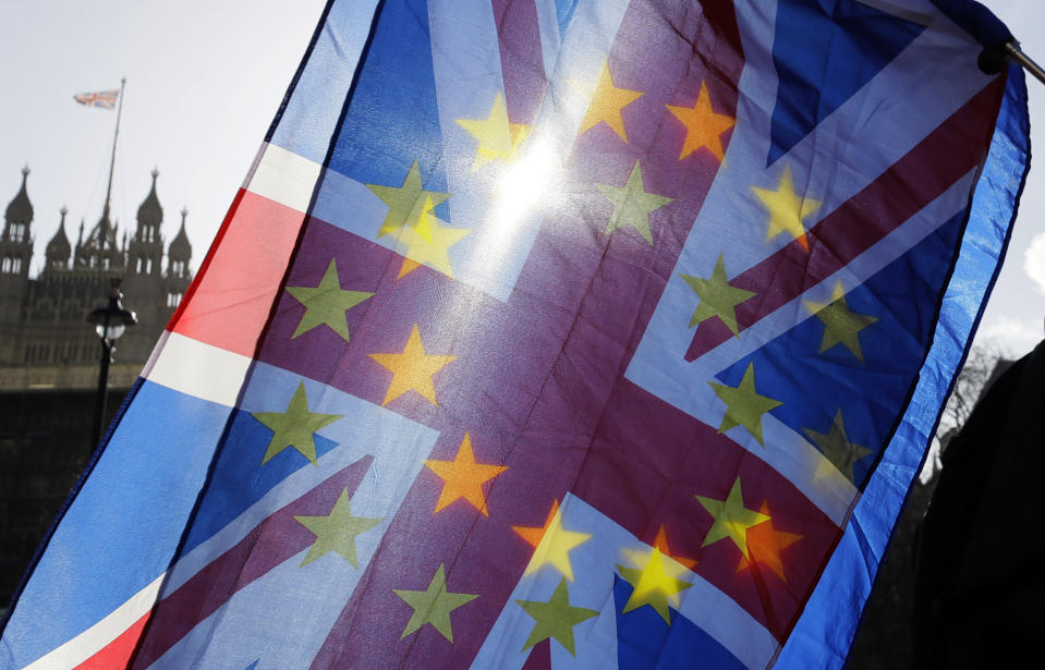 FILE - In this file photo dated Wednesday, Jan. 29, 2020, an anti-Brexit campaigner waves European Union and British Union flags outside Parliament in London. Millions of Europeans who have freely lived, worked and studied in the U.K. for decades, now have to apply to stay under the “settlement” plan, but the deadline for applications is Wednesday June 30, 2021. From Thursday July 1, any European person who hasn’t applied will lose their legal right to work, rent housing, access some welfare and hospital treatments in the U.K. and campaigners say many thousands may not have applied by the deadline. (AP Photo/Kirsty Wigglesworth, FILE)