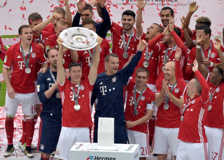 Bayern Munich's Robert Lewandowski holds the trophy as he and team celebrate winning their Bundesliga title, in Munich, on May 14, 2016