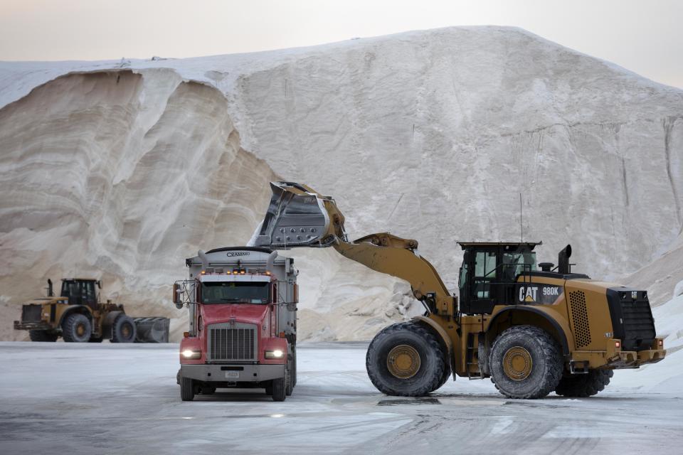 A front-end loader dumps road salt into a truck Friday, Jan. 28, 2022, in Chelsea, Mass. Residents and officials in the Northeast and mid-Atlantic regions of the U.S. are bracing for a powerful winter storm expected to produce blizzard conditions Friday and Saturday. (AP Photo/Michael Dwyer)