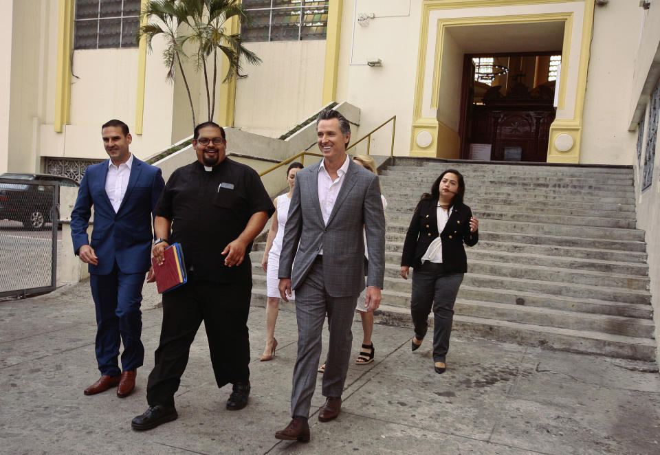 California Gov. Gavin Newsom, second from right, walks out with San Salvador Mayor Ernesto Muyshondtof, far left, after they visited the tomb of Archbishop Oscar Romero at Metropolitan Cathedral in San Salvador, El Salvador, Sunday, April 7, 2019. Behind are, from left, Karla Belismelis de Muyshondt, Jennifer Siebel Newsom, California state Assemblywoman Wendy Carrillo. (AP Photo/Salvador Melendez)