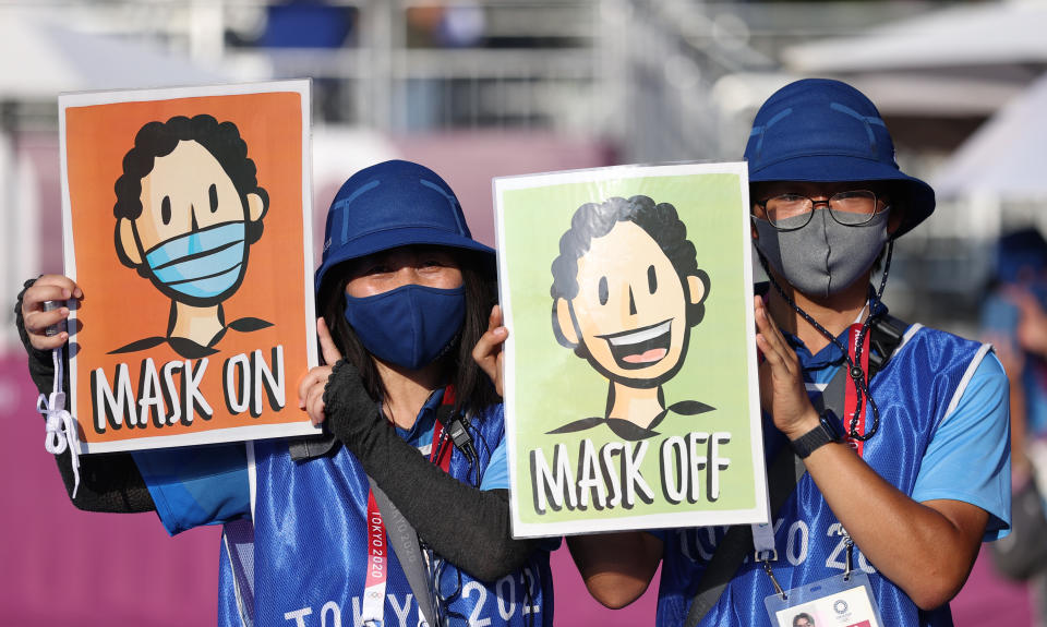 <p>People hold posters with a message "Mask on, Mask off" during the women's archery team qualification event at the 2020 Summer Olympic Games, at Yumenoshima Final Field. Sergei Bobylev/TASS (Photo by Sergei Bobylev\TASS via Getty Images)</p> 