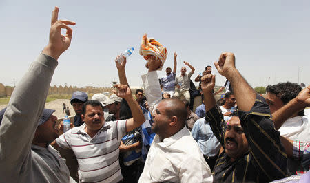 Volunteers who have joined the Iraqi Army to fight against the predominantly Sunni militants, who have taken over Mosul and other Northern provinces, chant slogans as they travel in an army truck, in Baghdad, June 12, 2014. REUTERS/Ahmed Saad