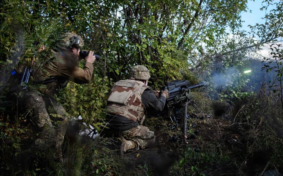 A soldier of Ukraine's 5th Regiment of Assault Infantry fires a US-made MK-19 automatic grenade launcher - DAVE CLARK/AFP