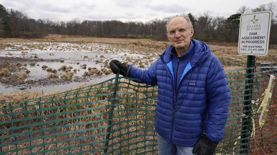 Community activist Bert Stratton stands near Horseshoe Lake, Tuesday, Dec. 7, 2021, in Cleveland Heights, Ohio. “The lake is a beautiful, calming feature that is the central park of the Heights neighborhood,” said Stratton, a resident helping to lead the efforts to save the lake. “It’s where people come to congregate, and they have for over 100 years.” (AP Photo/Tony Dejak)