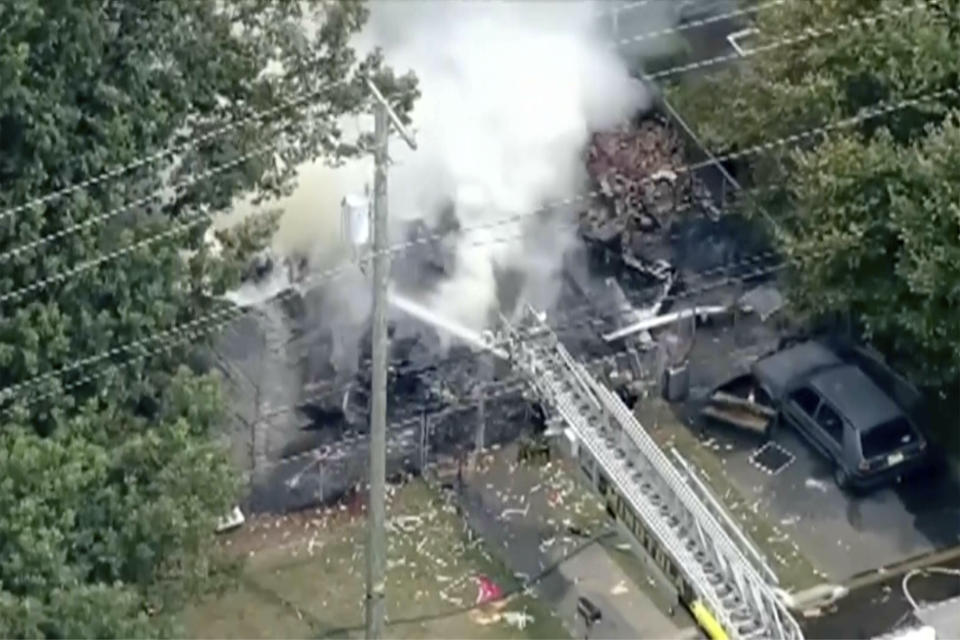 In this image taken by video from WPVI, fire crews try to extinguish an fire at a home Thursday, Aug. 3, 2023, in Buena, southern N.J. An explosion has destroyed the house and left two people dead and two children seriously injured. Authorities are still searching for two other people they believe were inside. (WPVI-TV via AP)