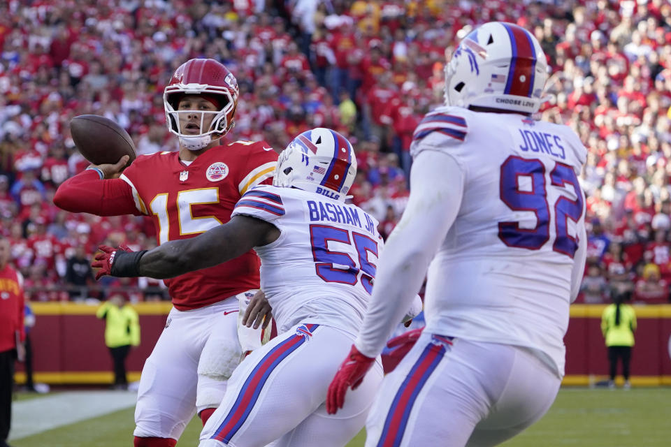 Kansas City Chiefs quarterback Patrick Mahomes (15) throws under pressure from Buffalo Bills defensive end Boogie Basham (55) and defensive tackle DaQuan Jones (92) during the first half of an NFL football game Sunday, Oct. 16, 2022, in Kansas City, Mo. (AP Photo/Ed Zurga)