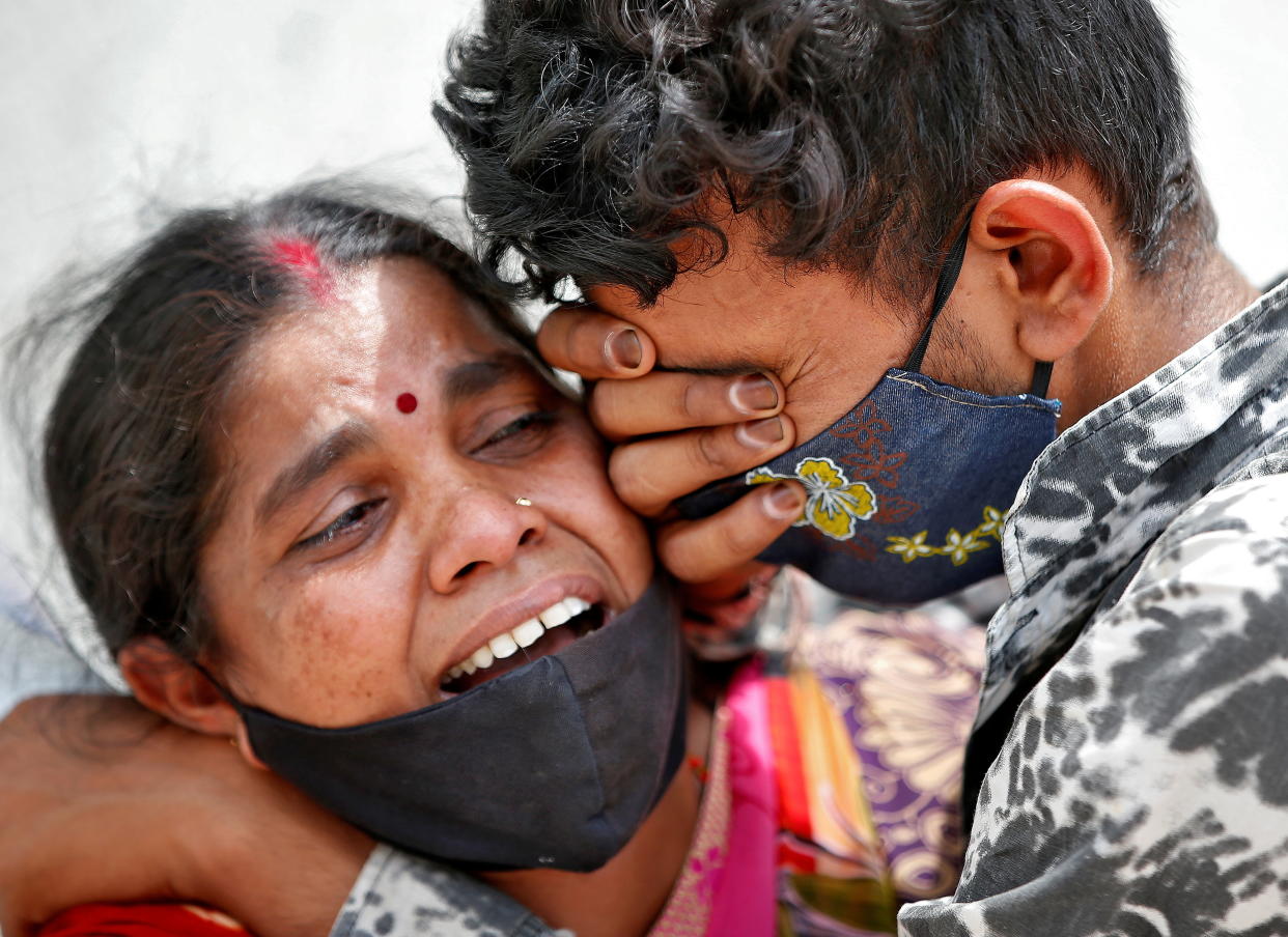 A woman mourns with her son after her husband died due to the coronavirus outside a mortuary of a Covid hospital in Ahmedabad, India, April 20, 2021.
