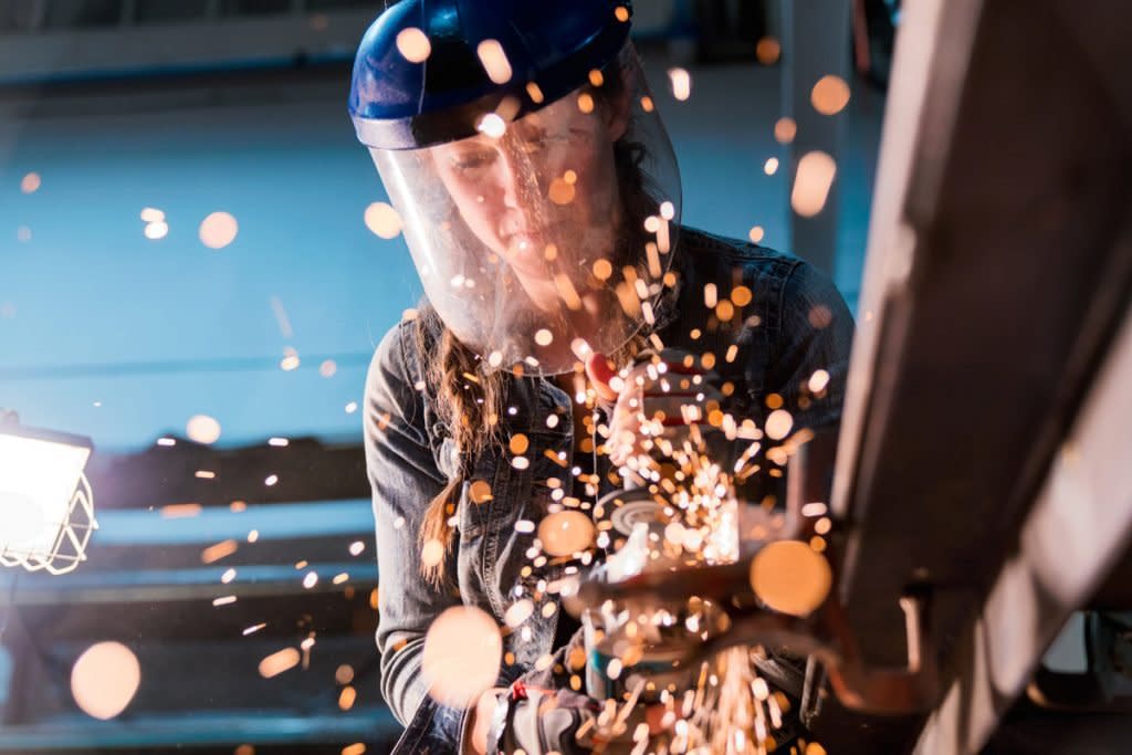 A female welder works. 