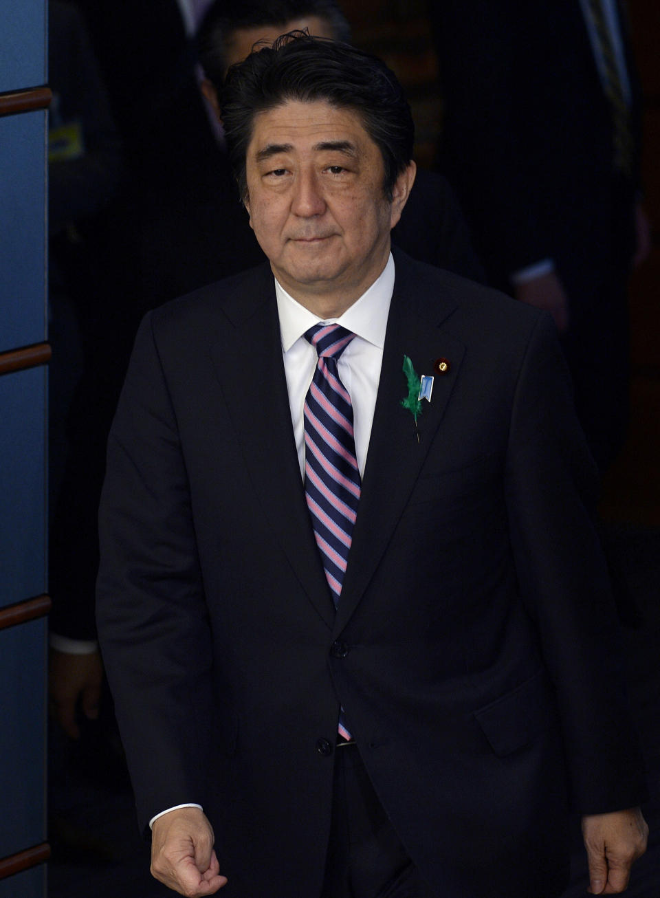 Japanese Prime Minister Shinzo Abe walks on his way to meet a delegation of US representatives at the premier's official residence in Tokyo, Japan, Monday, April 21, 2014. Japan's Prime Minister Abe has sent a religious offering to a Tokyo shrine that honors the dead including executed war criminals, a center of tension with Japan's neighbors. Abe's offering Monday at the Yasukuni Shrine marks the April 21-23 spring festival, one of the shrine's key annual events. But the move suggests he will not visit Yasukuni ahead of President Barack Obama's visit beginning Wednesday. (AP Photo/Franck Robicon, Pool)