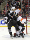 New Jersey Devils defenseman Ryan Graves (33) checks Philadelphia Flyers left wing James van Riemsdyk (25) during the second period of an NHL hockey game Wednesday, Dec. 8, 2021, in Newark, N.J. (AP Photo/Bill Kostroun)