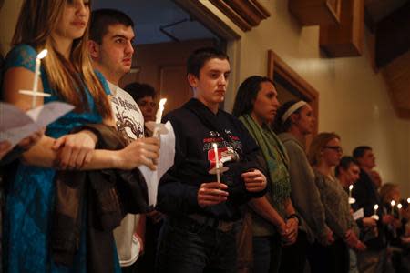 People hold candles during a prayer vigil for victims of the Franklin Regional High School stabbing rampage, at Mother of Sorrows Roman Catholic Church in Murrysville, Pennsylvania April 9, 2014. REUTERS/Shannon Stapleton