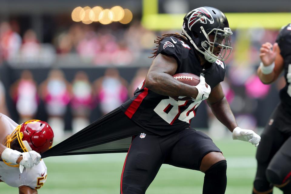 Cordarrelle Patterson #84 of the Atlanta Falcons runs with the ball as Jon Bostic #53 of the Washington Football Team tries to bring Patterson down in the third quarter at Mercedes-Benz Stadium on October 03, 2021 in Atlanta, Georgia.