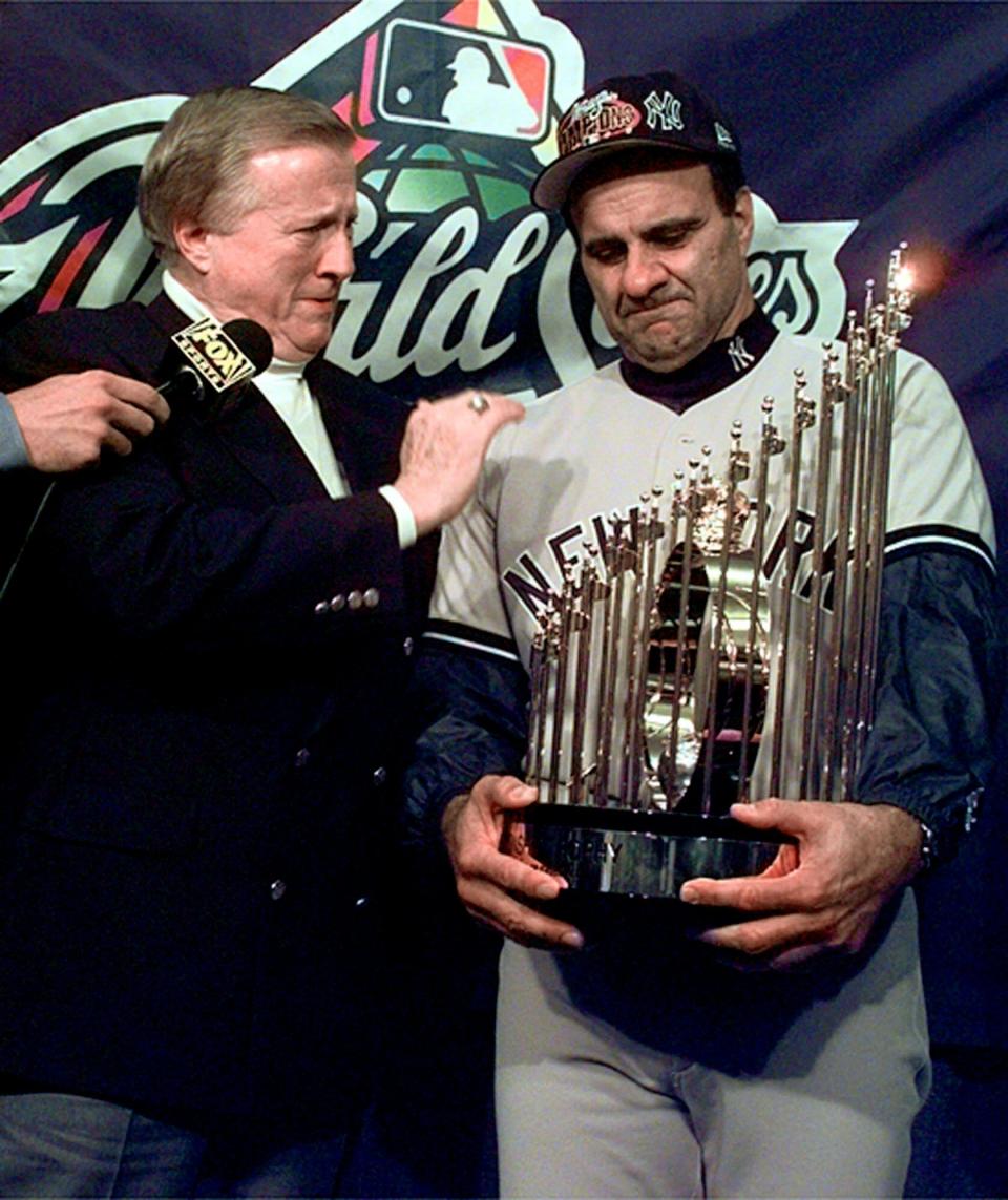 Yankees team owner George Steinbrenner and manager Joe Torre get emotional after being presented with the trophy after the Yankees swept the San Diego Padres to win the 1998 World Series.