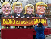 <p>A reveller takes a picture of a carnival float depicting US president Donald Trump with Marine Le Pen, Geert Wilders and Adolf Hitler, reading ‘blonde is the new brown’ prior the traditional carnival parade in Duesseldorf, Germany, on Monday, Feb. 27, 2017. The foolish street spectacles in the carnival centers of Duesseldorf, Mainz and Cologne, watched by hundreds of thousands of people, are the highlights in Germany’s carnival season on Rose Monday. (AP Photo/Martin Meissner) </p>