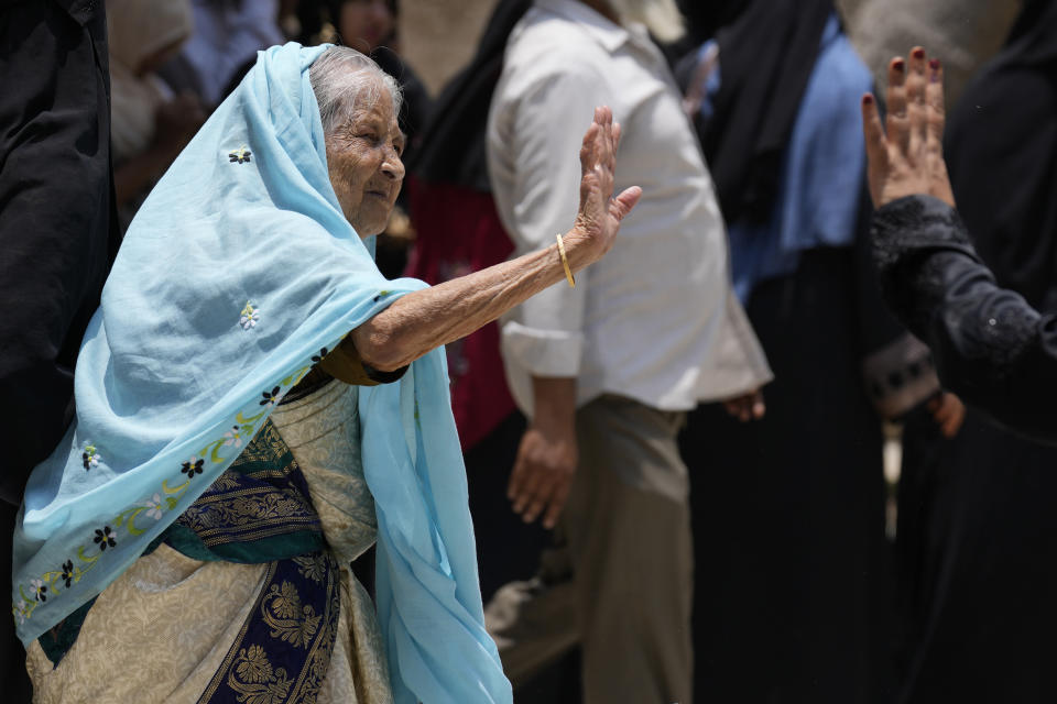 An elderly woman waves goodbye to a relative after casting her vote at a polling station in Bengaluru, India, Wednesday, May 10, 2023. People in the southern Indian state of Karnataka were voting Wednesday in an election where pre-poll surveys showed the opposition Congress party favored over Prime Minister Narendra Modi's governing Hindu nationalist party. (AP Photo/Aijaz Rahi)
