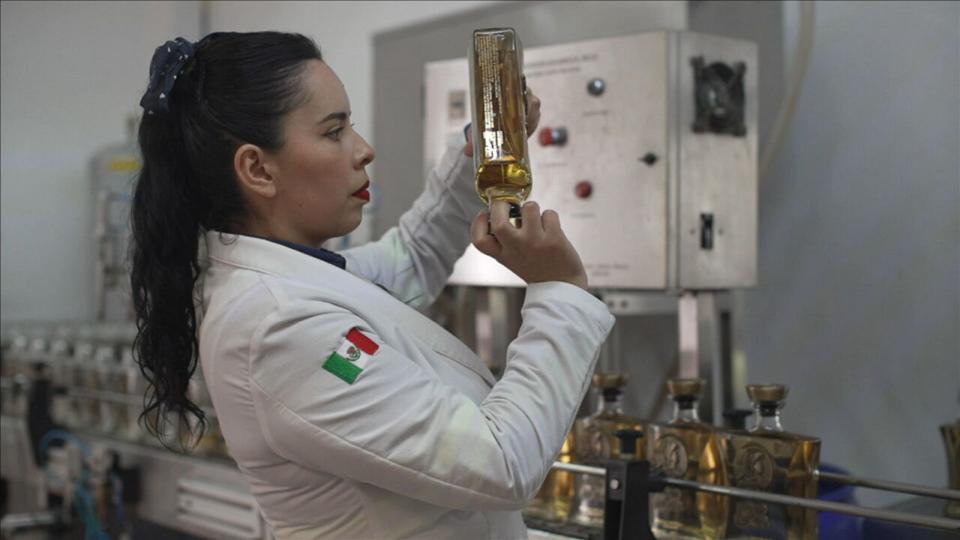 PHOTO: Sandra, a head chemist for the tequila distillery owned by Melly Bajaras, holds up a bottle of tequila in Jalisco, Mexico. (ABC News)