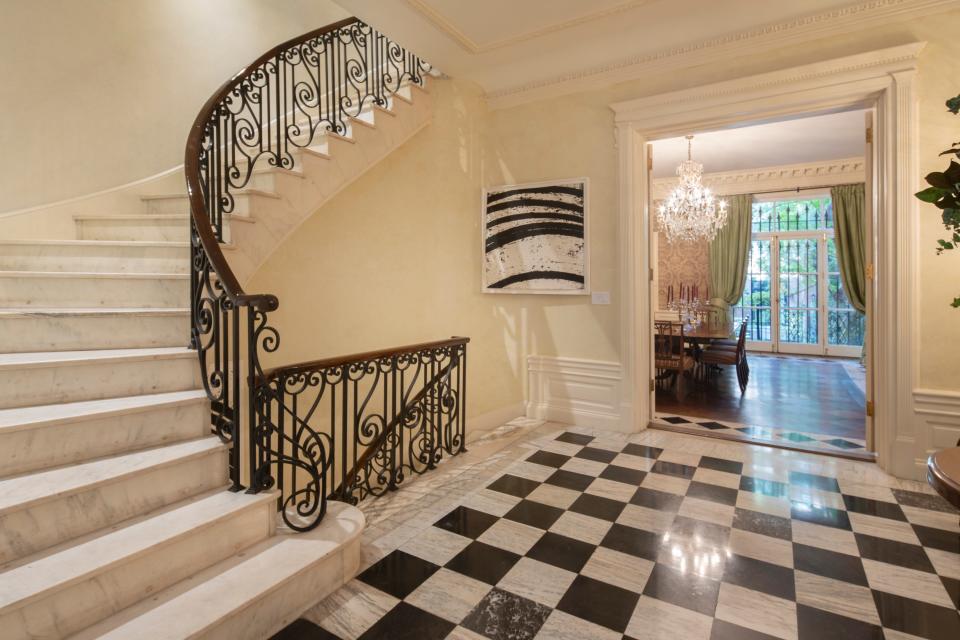 A checkerboard floor decorates the foyer and landing.