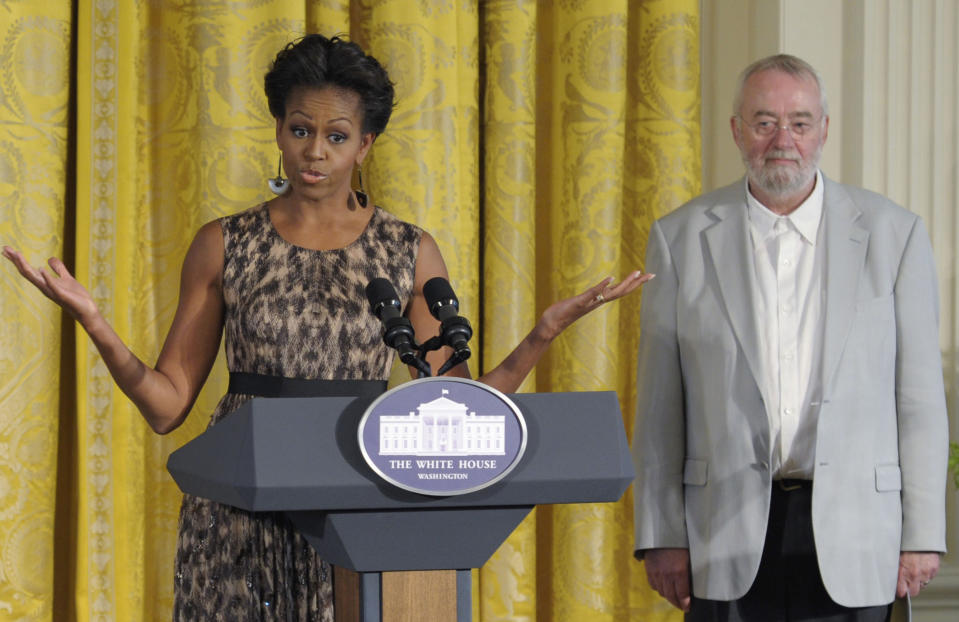 FILE - In this Tuesday, Sept. 13, 2011 file photo, Bill Moggridge, the director of the Smithsonian's Cooper-Hewitt, National Design Museum, stands at right as first lady Michelle Obama speaks in the East Room of the White House in Washington during the Smithsonian's Cooper Hewitt National Design Awards luncheon. Moggridge, a British industrial designer who designed an early portable computer with the flip-open shape that is common today, has died. He was 69. The museum said Moggridge, its director since 2010, died on Saturday, Sept. 8, 2012 after a battle with cancer. (AP Photo/Susan Walsh)