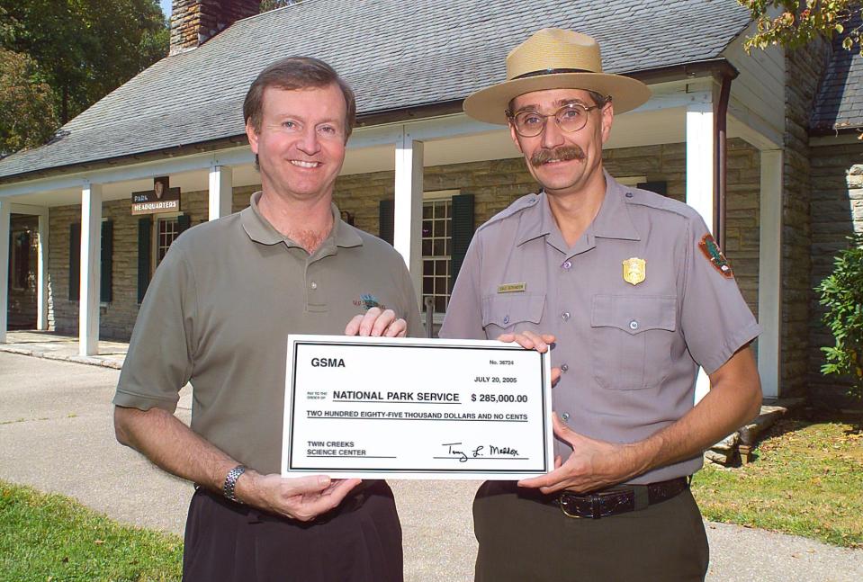 Terry Maddox, left, presents former park superintendent Dale Ditmanson with a check for $285,000 that would help to build the Twin Creeks Science and Education Center, completed in 2007 near Gatlinburg, Tennessee.